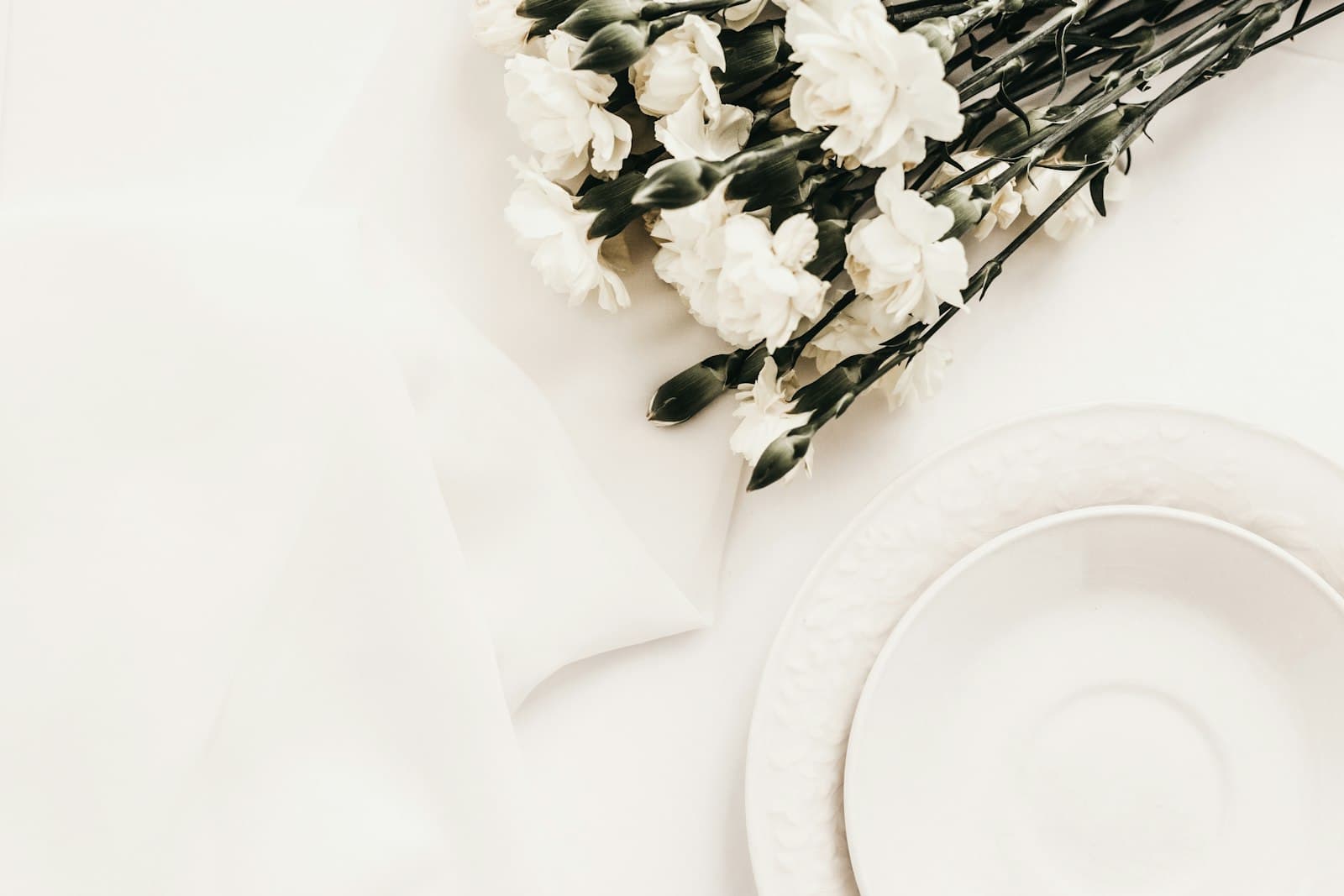 A neutral table setting with ceramic plates and linen